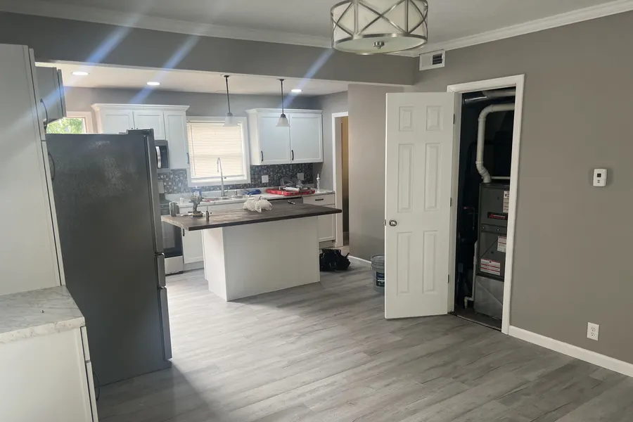 A kitchen remodel by ZKB nearing completion: new white cabinets and an island being fitted.